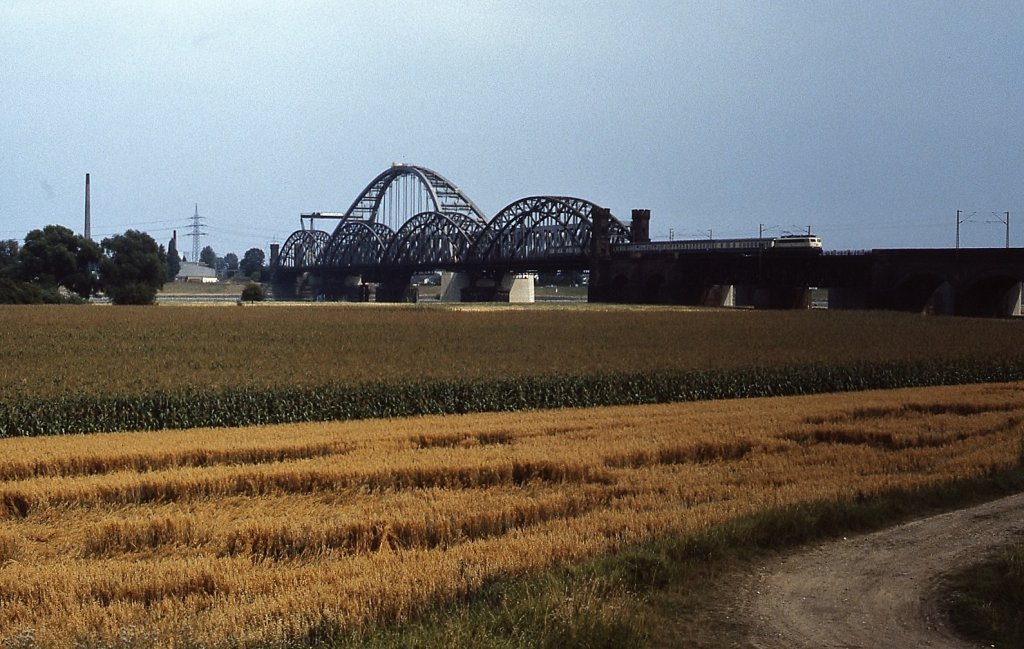 Eine 110.3 fährt im Sommer 1986 über die alte Rheinbrücke Düsseldorf-Neuss. Zu diesem Zeitpunkt ist die neue Brücke bereits weitgehend fertiggestellt.