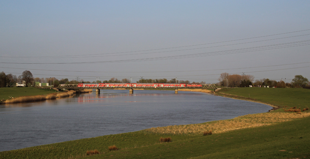 Eine 111 fuhr am 03.05.2013 mit einem RE von Emden nach Mnster ber die Ledabrcke sdlich von Leer.