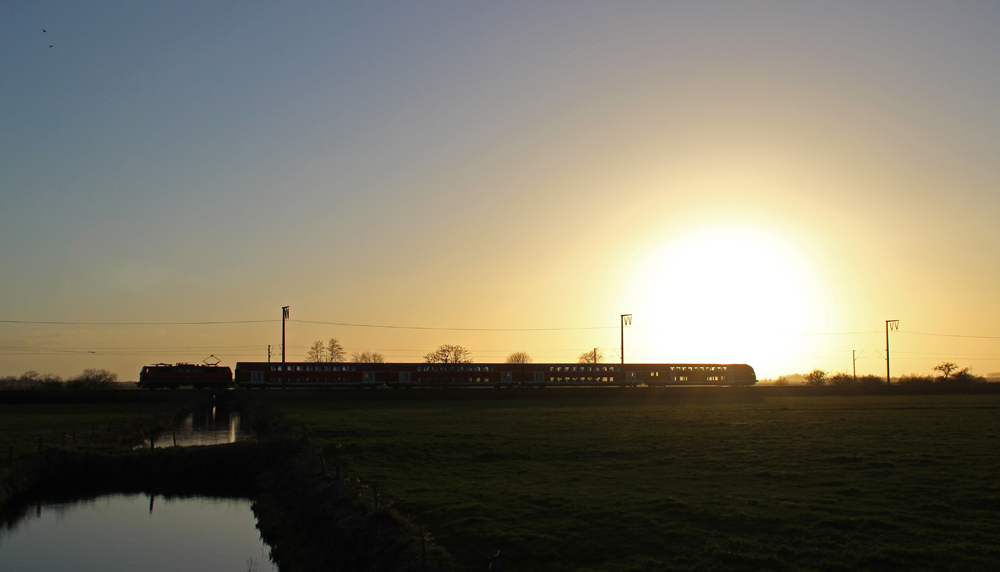 Eine 111 fuhr am 19.04.2013 mit einem RE von Emden nach Mnster, hier bei Veenhusen.