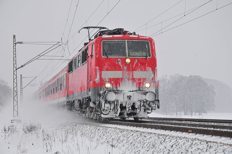 Eine 111er mit Regionalzug in Richtung Salzburg kmpft sich durch den Schnee bei bersee am 20.01.13.