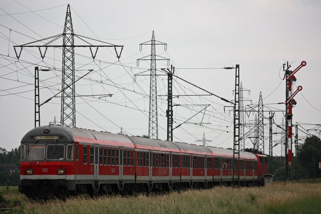 Eine 111er schiebt einen n-Wagenzug durch Neuss-Weienberg.
Aufgenommen am 18.6.12.