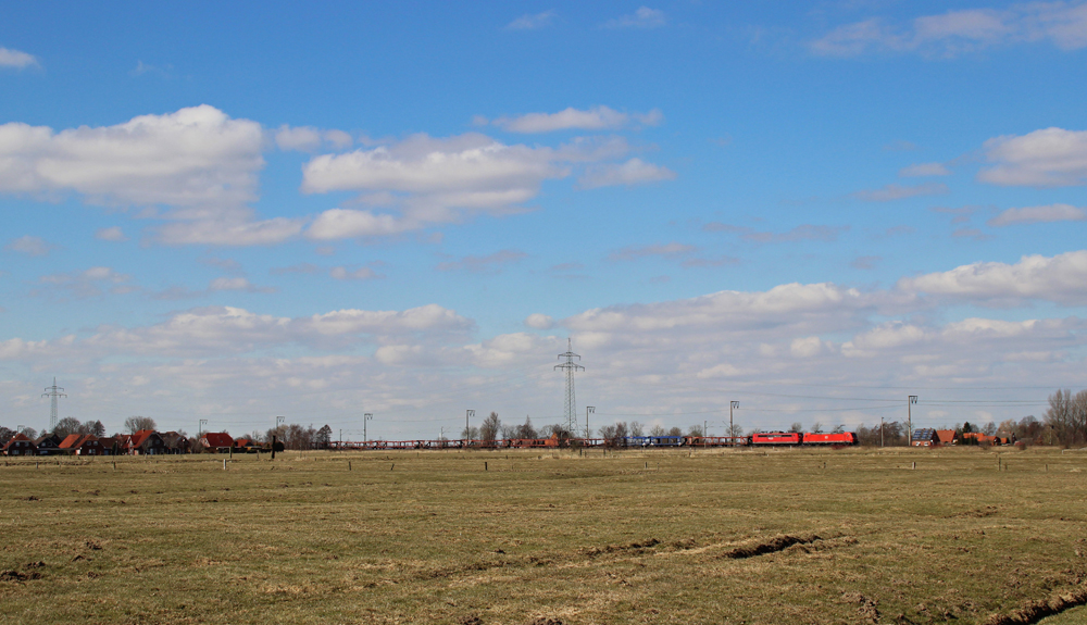 Eine 185 fuhr am 26.03.2013 mit einer 151 im Schlepp und einem leeren Autozug von Emden nach Osnabrck, hier bei Rorichum.