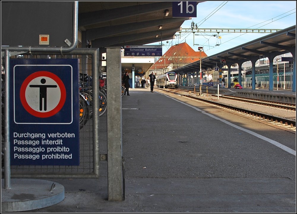 Eine altbekannte international vielgestaltige Tafel grenzt den Schweizer Teil des Bahnsteig 1 im Bahnhof Konstanz vom deutschen Teil ab. Genau hingeblickt, fehlt hier etwas. Auch wenn es nur 200 Meter sind, ein weiteres Stck Grenzzaun ist verschwunden. Nur ein winziges Stck Grenzzaun, doch ein symboltrchtiges. War einst hier die freizgigste echte Grenze in Europa entstanden, so war im Laufe der Zeit mit dem Schengen-Abkommen der Rckstand der Schweiz zum offenen Europa nicht mehr zu bersehen. So hat sich nun mit deutlich mehr als halbjhriger Versptung auch die Schweiz dazu durchgerungen, den Geist von Schengen nicht nur als Zugriffsrecht auf die europischen Polizeidaten zu verstehen. (Weihnachten 2009)
