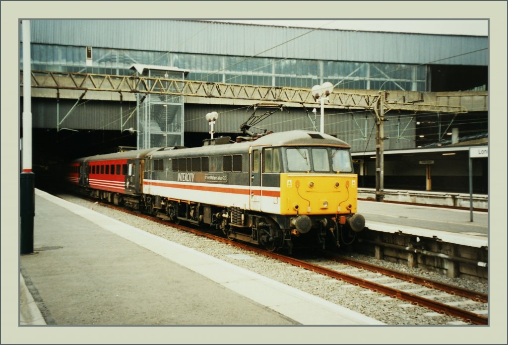 Eine Class 86 noch in BR Intercity-Lackierung wartet mit einem  Virgin -Schnellzug auf die Abfahrt in Euston.
London, den 20. Sept. 1999