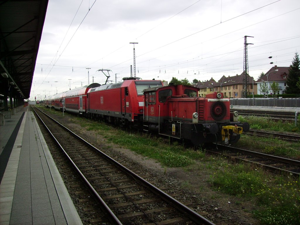 Eine Kleindiesellok steht am 12.08.2011 auf einem Nebengleis, vor einem abgestellten RE, im Bahnhof Offenburg.
