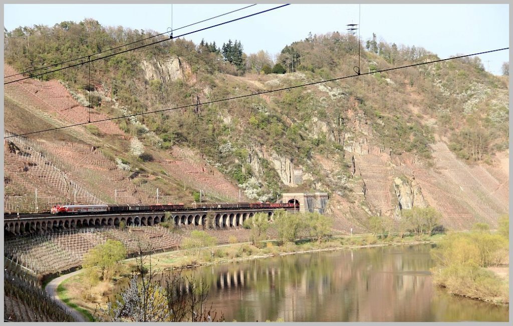Eine mir leider unbekannte Diesellok ist mit einem Gterzug, an der Spitze zwei ex-Silberlinge, am Abend des 2. April 2012 auf dem Pndericher Hangviadukt Richtung Trier unterwegs. 