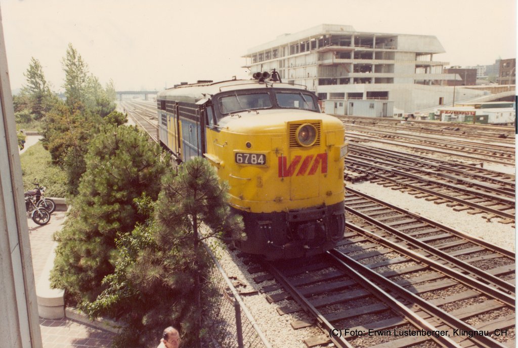 Eine nach CN (Canadien National) Class bezeichnete MPA-18b (M = Montreal Locomotive Works oder American Locomotive Works (Alco), P = Personenverkehr, A = mit Fhrerstand (A-Unit), 18 = 1'800 PS, b = Unterklasse (es gab a, b, c) bzw. Erbauertyp FPA-4 von ALCO (American Locomotive Company) Nr. 6784 der Via Rail in Toronto auf dem Bahnhofgelnde vor dem CN-Tower. Die Lok wiegt 116t und hat vier Achsen. Pro Achse sind dies 29t was fr Europa viel zu schwer wre. Baujahr 1955 bis 1959. Die 1.800 PS (1.300 kW) der FPA-4/FPB-4 wurden durch einen 251V-12-Motor erreicht. Erbaut wurden die Loks durch die kanadische Tochtergesellschaft ALCO's, Montreal Locomotive Works (MLW). Aufnahme vom 13.07.1981. Aufnahmedatum: 13.07.1981.
