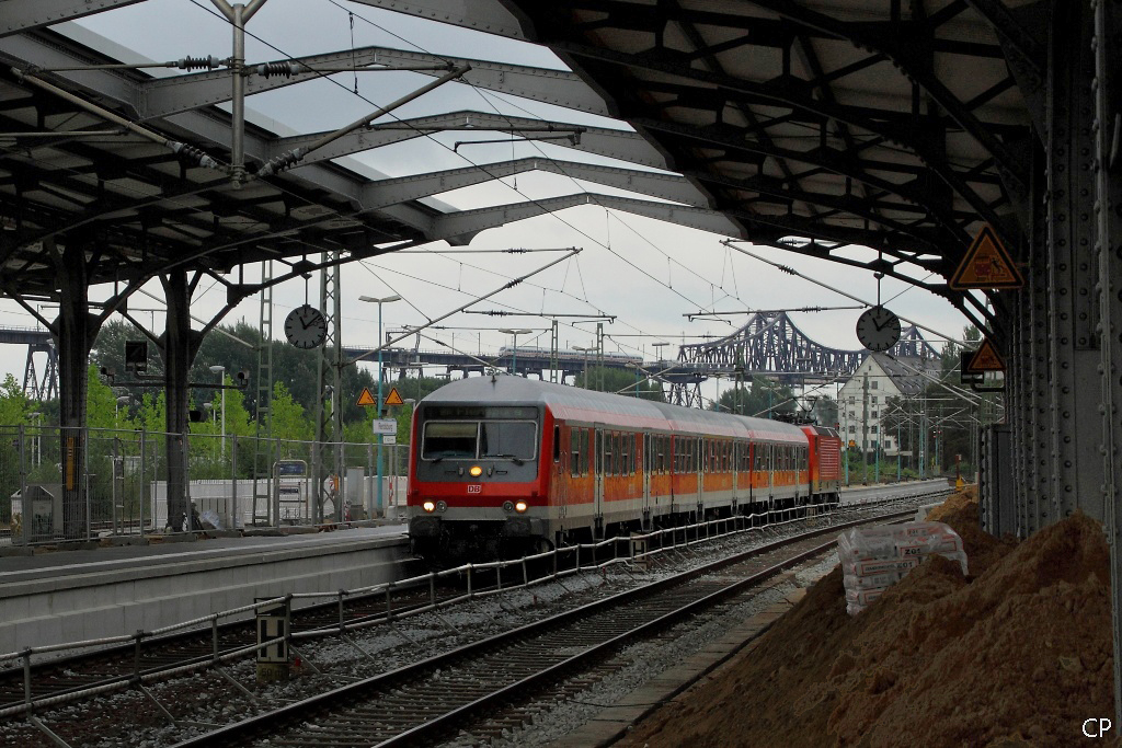 Eine RB nach Flensburg erreicht geschoben von einer 143 den Bahnhof Rendsburg. Im Hintergrund passiert ein ICE-TD die Hochbr�cke. (22.8.2010)