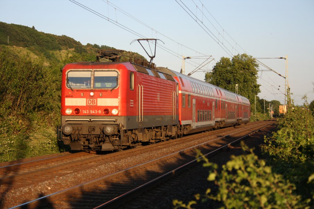 Eine RB nach Kln Hbf bei der Durchfahrt in Leutesdorf am Rhein am Abend des 02.06.2011. Zuglok war die 143 943-9.