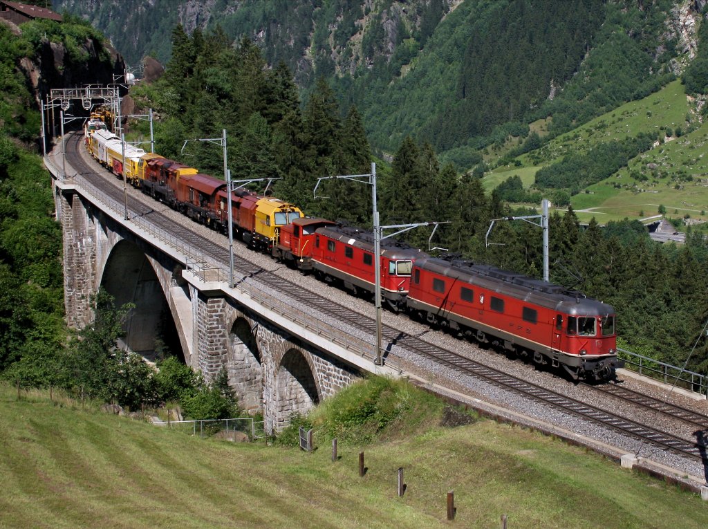 Eine Re 10/10 angefhrt von der Re 6/6 11615 am 27.06.2011 mit einem Bauzug unterwegs bei Wassen. 