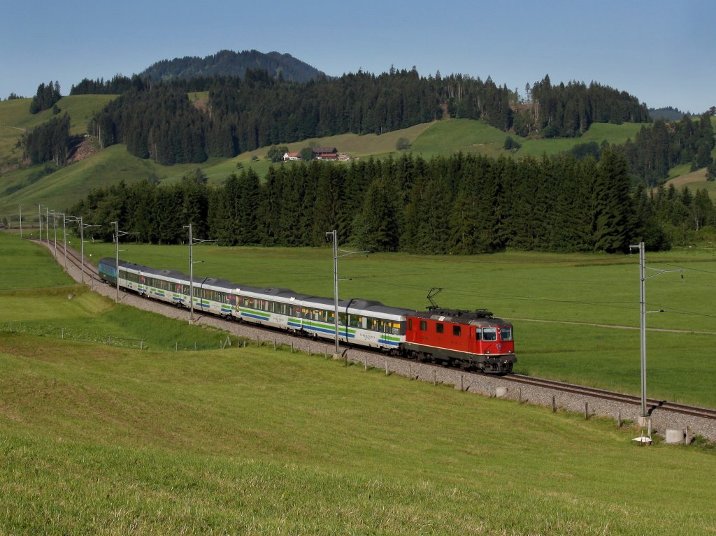 Eine Re 4/4 mit einem Voralpenexpress am 27.06.2011 unterwegs bei Altmatt. 