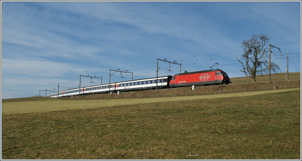 Eine Re 460 schiebt ihren IR von Luzern nach Genve Aroport durch das leicht hglige Freiburger Land bei Chenens .
12. Mrz 2012