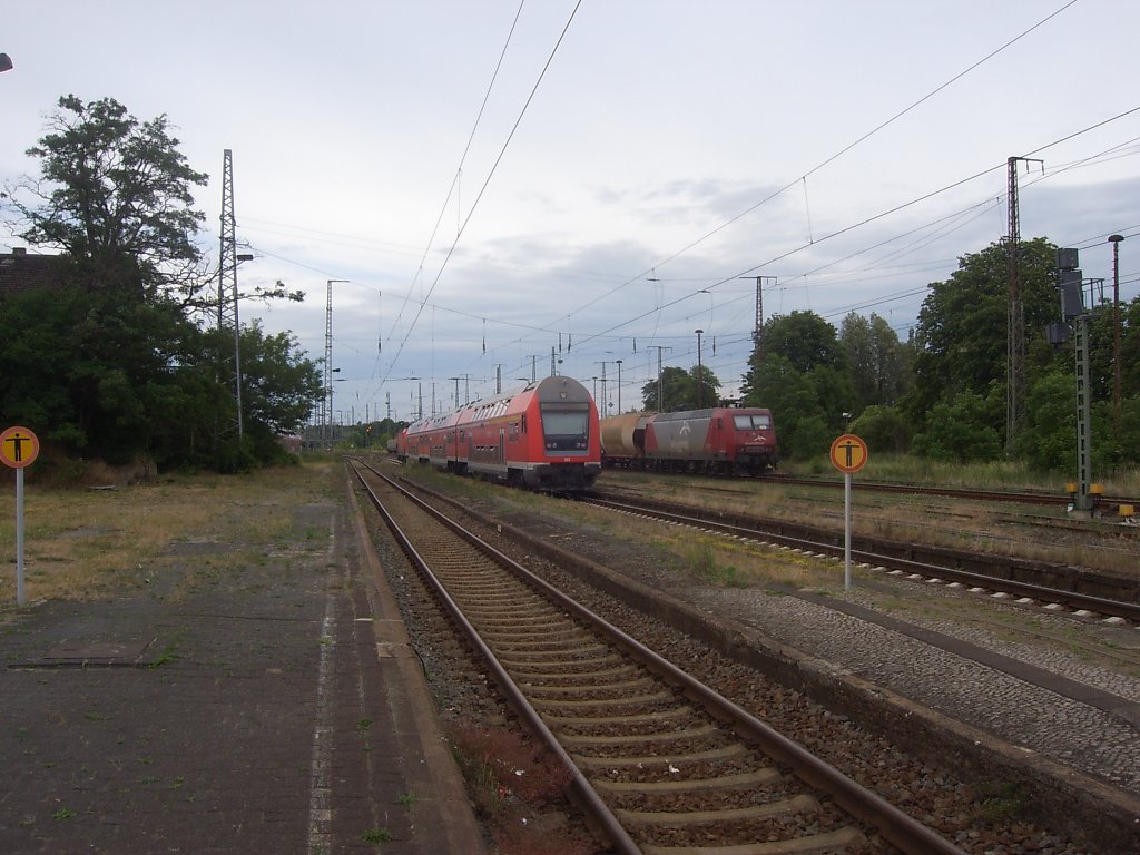 Eine Regionalbahn (+25 min) verlsst gerade den Bahnhof Lutherstadt Wittenberg  und fhrt Richtung Falkenberg weiter. 
Die Lok der BR 145 von EKO-Trans steht abgstellt da und sonnt sich in der Abendsonne. 
Aufgenommen am 13.06.2011
