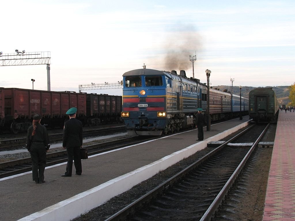 Eine reich qualmende “Halbe Doppellok“ 2TE10U – 282 (2TЗ10y – 0282) fahrt mit ein “TsarenGold“-Zug auf Bahnhof Naoesjki (Наушки) ein am 14-9-2009, beobachtet durch die viele Zollbeambter. Bahnhof Naoesjki ist ein Grenzbahnhof zwischen Russland und Mongolei.