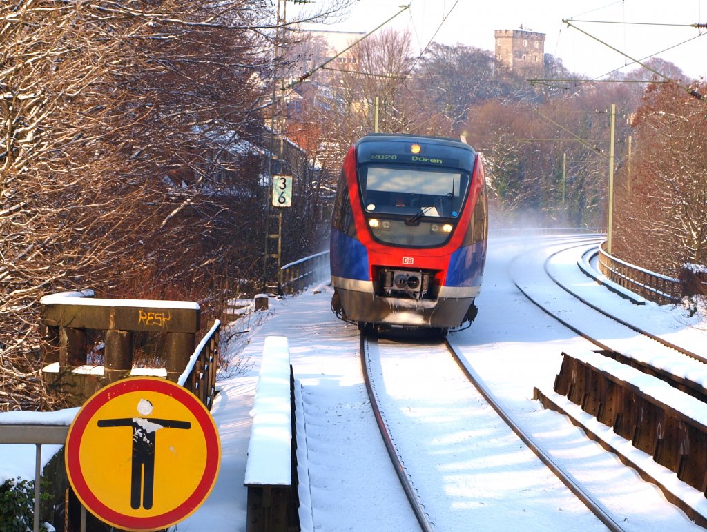 Eine Schneewolke hinter sich herziehend kommt der Talent der Euregiobahn RB20 nach Dren in die Halterstelle Aachen Schanz. Im Hinter grund der Pulverturm an der Turmstrasse in Aachen.