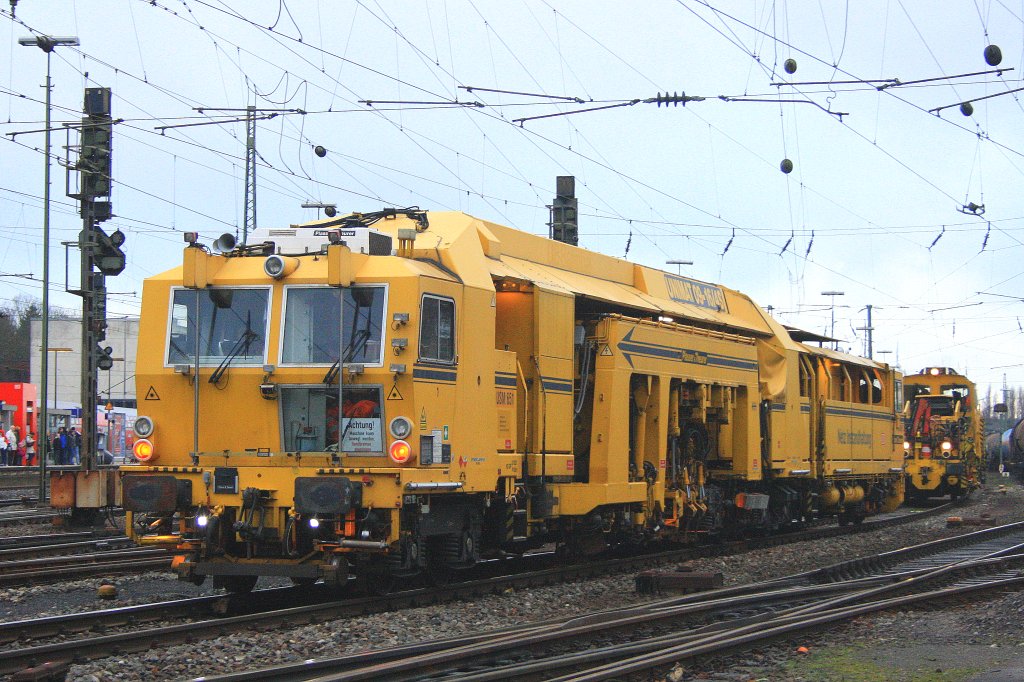 Eine Stopfmaschine und ein Schotterprofiliermaschine arbeiten  am 18.12.2011 in Aachen-West.
