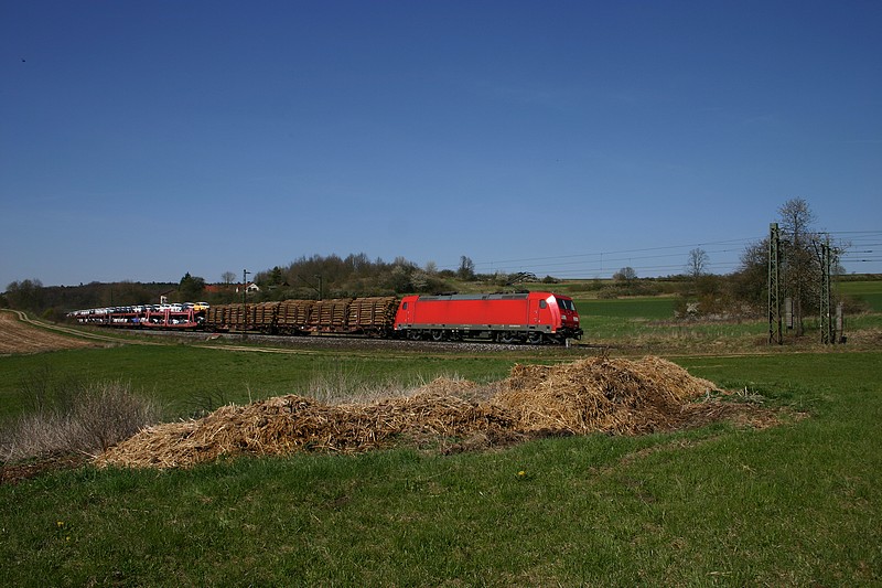 Eine unbekannt gebliebene Lok der BR-185 hat sich an der Fotostelle bei Edlhausen mit einem (zum Glck nicht bel riechenden) Misthaufen an der KBS 880 in Szene setzen lassen.(24.04.2010)