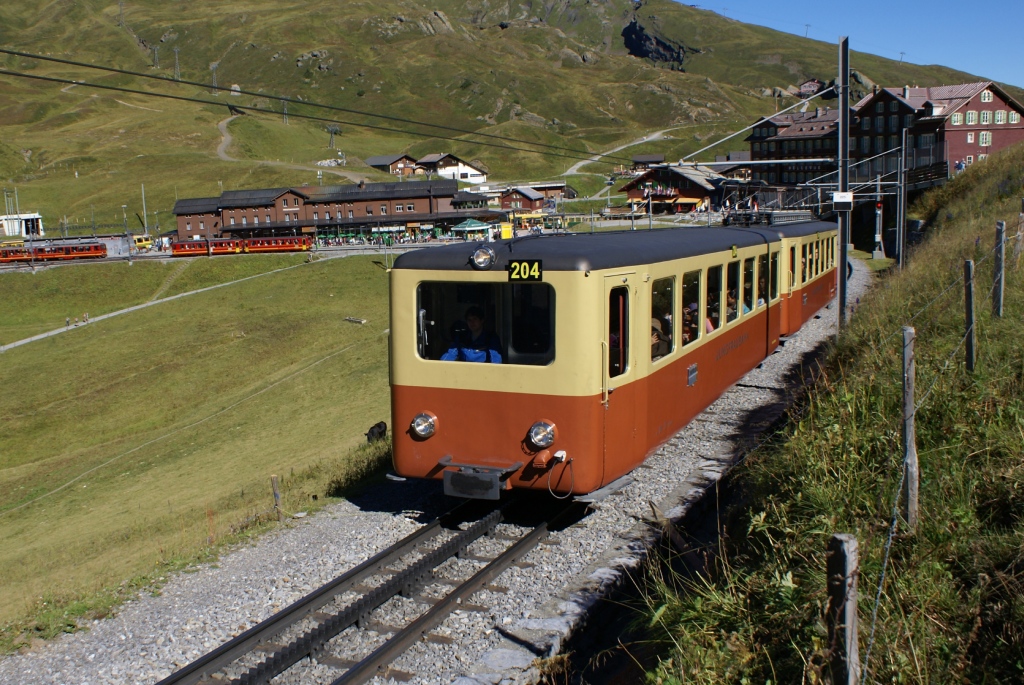 Eine der wenigen Stellen, wo man die Jungfraubahn auf freier Strecke fotografieren kann, befindet sich oberhalb der kleinen Scheidegg. Am 26.8.10 macht sich ein noch in der alten Lackierung verkehrender Zug, bestehend aus dem Bt 31 und dem BDhe 2/4 204, auf den Weg Richtung Jungfraujoch.