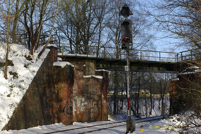 Einfahrsignal nach Buchholz (Nordheide) der Heidebahn (KBS 123) vor der Brcke der ehemaligen Bahnstrecke Buchholz - Hollenstedt - (Bremervrde) am 1.1.2011 und dem ersten Sonneschein in 2011. Im Hintergrund ein Metronom.

 Jan Schuur 2011 http://bahn.schuur-nordheide.de