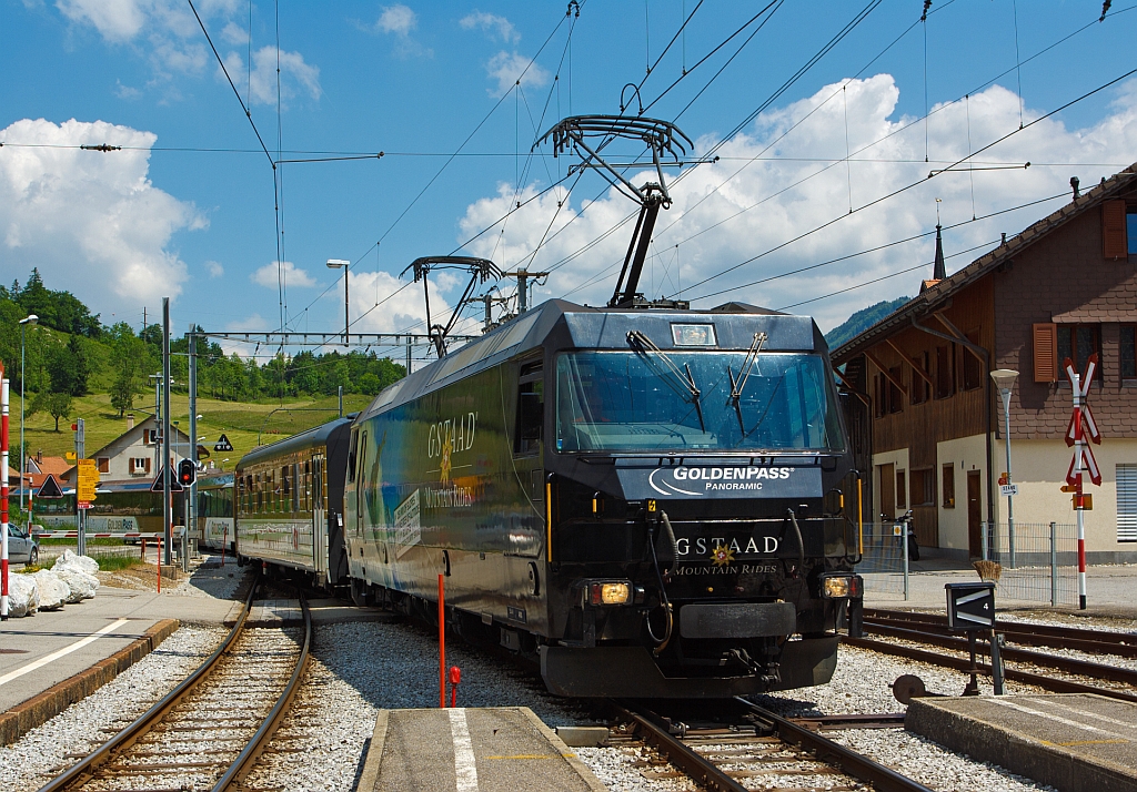 Einfahrt der MOB Ge 4/4 8001 mit dem Goldenpasszug am 28.05.2012 in den Bahnhof Montbovon, mit diesen Zug fahren wir dann nach Zweisimmen. Aktuell wirbt die 8001 fr die Gstaader Tourismus-Organisation „Gstaad Mountain Rides“.  Seit 1995 sind diese leistungsstrksten schweizerischen Gleichstrom-Triebfahrzeuge bei der MOB im Einsatz. Die Ge 4/4 der MOB sind bereits fr einen Zwei-System-Betrieb vorbereitet, fr den Fall, dass eine dritte Schiene zwischen Zweisimmen und Interlaken tatschlich irgendwann einmal installiert wird, im Lokkasten ist noch Platz fr einen Transformator fr den Betrieb bei 15 kV mit 16 2/3 Hz Wechselstrom, ein dritter Pantograph lsst sich nachrsten.