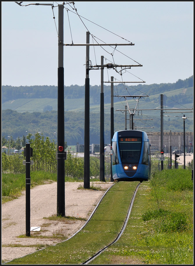 Eingleisige Überlandstraßenbahn - 

Südlich der Station  Léon Blum  durchfährt die Linie B auf vorläufig eingleisiger Trasse noch unbebautes Gebiet, ohne Halt bis zum  Gare Champagne TGV . Das Gebiet in diesem Bereich soll noch aufgesiedelt werden, dann wird der Abschnitt zweigeleisig ausgebaut und zwei weitere Haltestellen werden nachgerüstet. Auf der rechten Seite des Fotostandpunktes befindet sich das Tram-Depot. 

24.07.2012 (J)