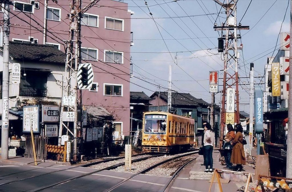Einst und jetzt: Nishigahara Yonchôme im alten nördlichen Stadtteil von Tokyo. Wagen 7020 legt sich in die Kurve, um den Berg hinabzufahren. Noch ist der gelbe Anstrich üblich. 7.März 1978. 