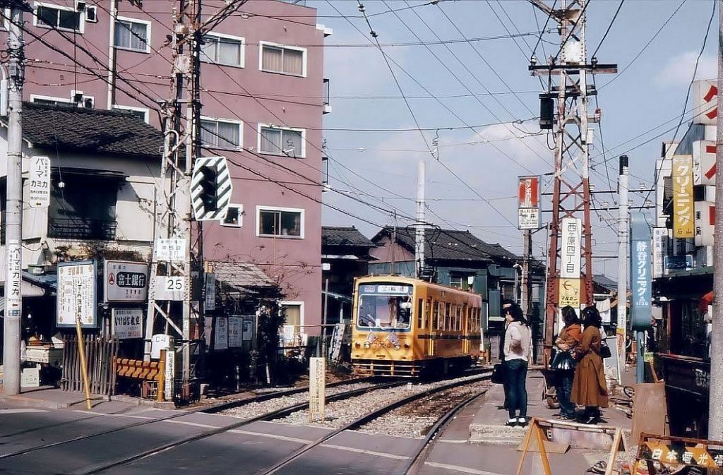 Einst und jetzt: Nishigahara Yonchme im alten nrdlichen Stadtteil von Tokyo. Wagen 7020 legt sich in die Kurve, um den Berg hinabzufahren. Noch ist der gelbe Anstrich blich. 7.Mrz 1978. 