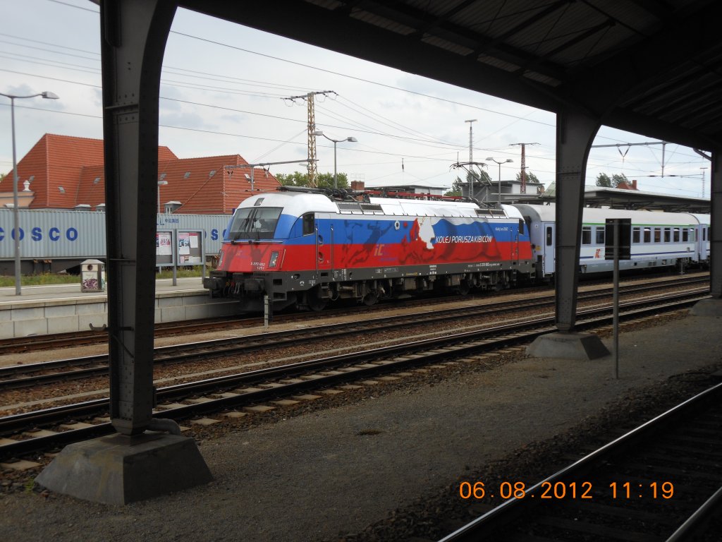 EM-Lok  Ruland  der Polnischen Eisenbahnen im Bahnhof Frankfurt an der Oder whrend eines Zwischenhaltes auf dem Weg nach Berlin. Das alte Bahnhofsgebude mit seinen Stahltrgern und den dazwischenliegenden Glasflchen mag fr Eisenbahnnostalgiker recht interessant sein; dennoch mu man sagen, da der Bereich um den Bahnhof einen beraus tristen Eindruck hinterlt. Fast hat man den Eindruck, als ob seit der Wende im Jahr 1989 die Zeit stehen geblieben wre, was vielleicht auch an der etwas ungnstigen Lage der Stadt im uersten Osten Deutschlands liegen mag (Aufnahme vom 6.8.2012).