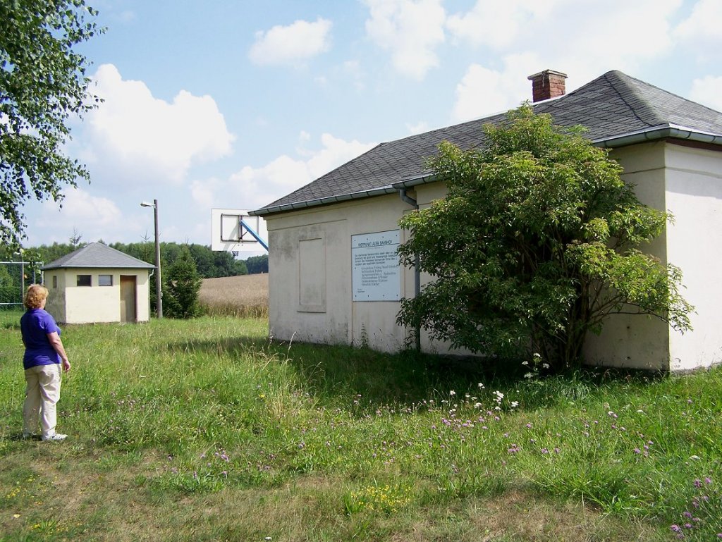 Empfangsbeude Oberschar mit Abtritt am 4. 8. 2010. Die groe Tafel verkndet stolz, da die Anlage 1993 durch eine Spendeaktion dreier Unternehmen saniert und in einen Jugendclub bzw. Sportanlage umfunktioniert wurde. Ob die Jugendlichen nun ihren Club durch das Gebsch direkt am Eingang betreten knnen...?