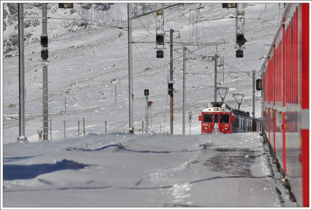 Endlich ist er da, der Schnee. Nur liegt er nicht immer dort, wo er sein sollte. Durch den eisigen Nordwind wurde das Gleis 2 in Ospizio Bernina 2253m zugeweht. Dank eines kirchlichen Feiertages in Italien, verkehrte ab dort ein Entlastungszug nach St.Moritz, sodass es um halb zwlf zur ersten Zugskreuzung im hchsten Bahnhof der RhB kam. Fast wie bei Tom Leitners Nebelbildern, war ich am richtigen Ort. BerninaExpress 1625 mit ABe 4/4 III 55  Diavolezza  und 51  Poschiavo  nhert sich Ospizio Bernina. (08.12.2011)