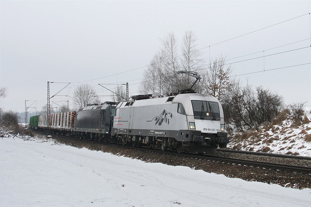 ES 64 U2 101 + 185 547 mit einem Holzzug am 16.01.2010 bei Ostermnchen.