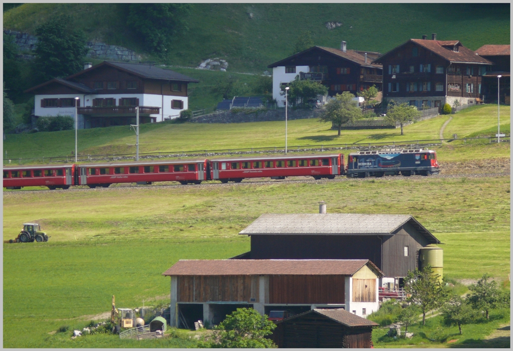Es riecht nach frischem Heu, wenn RE1229 nach Scuol durch frischgemhte Wiesen fhrt bei Klosters Dorf. (26.06.2010)
