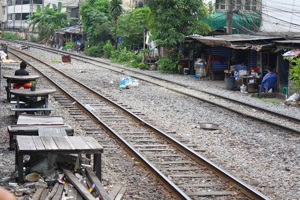 Etwa 200m vor dem Einfahrtsignal des Bf. Hua Lamphong in Bangkok befindet sich dieses Lokal, das die drei stark befahrenen Streckengleise berhaupt nicht kmmert. So etwa mssen Alptrume europische Ordnunghter aussehen. 24.August 2010.