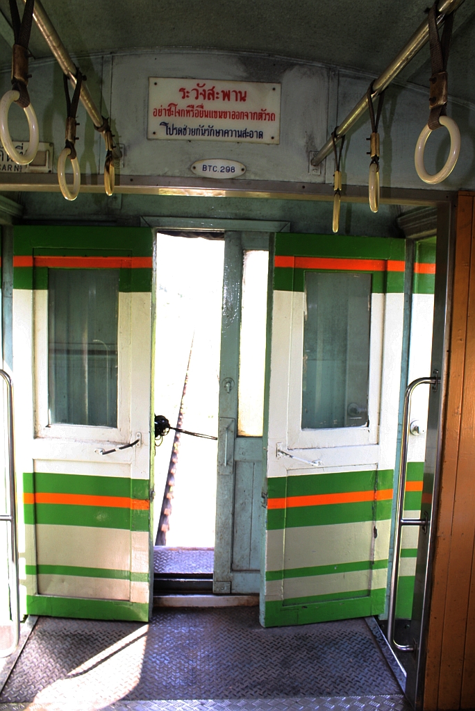 Fahren mit offenen Türen ist in Thailand nichts Aussergewöhnliches. บชส. 298 (บชส. =BTC./Bogie Third Class Carriage), aufgenommen während der Fahrt mit dem ORD 447 am 07.Jänner 2013 zwischen den Bf. Thung Song Junction und Sai Yai.
