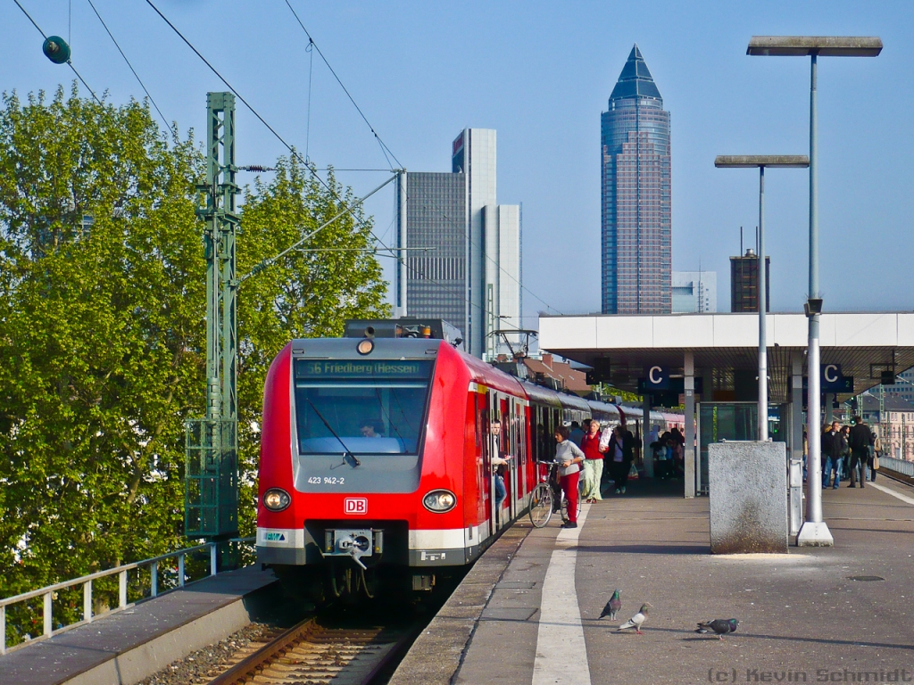 Fahrgastwechsel in Frankfurt (Main) West. Die eingefahrene ET423-Doppeltraktion fährt in Kürze als S6 weiter nach Friedberg (Hessen). Auch einige Tauben haben sich auf dem Bahnsteig dazugesellt. Im Hintergrund ist sehr gut der bleistiftförmige Messeturm erkennbar. (08.05.2010)