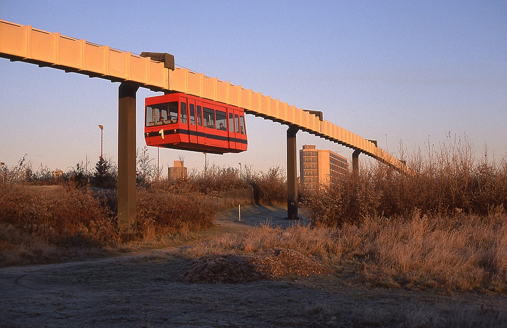 Fahrzeug 301 der H-Bahn Dortmund kurz vor Querung der Universittsstrae in Fahrtrichtung Campus Sd, Dezember 1989. Die Fahrzeugnummer 301 war nur innerhalb der Kabine angeschrieben.