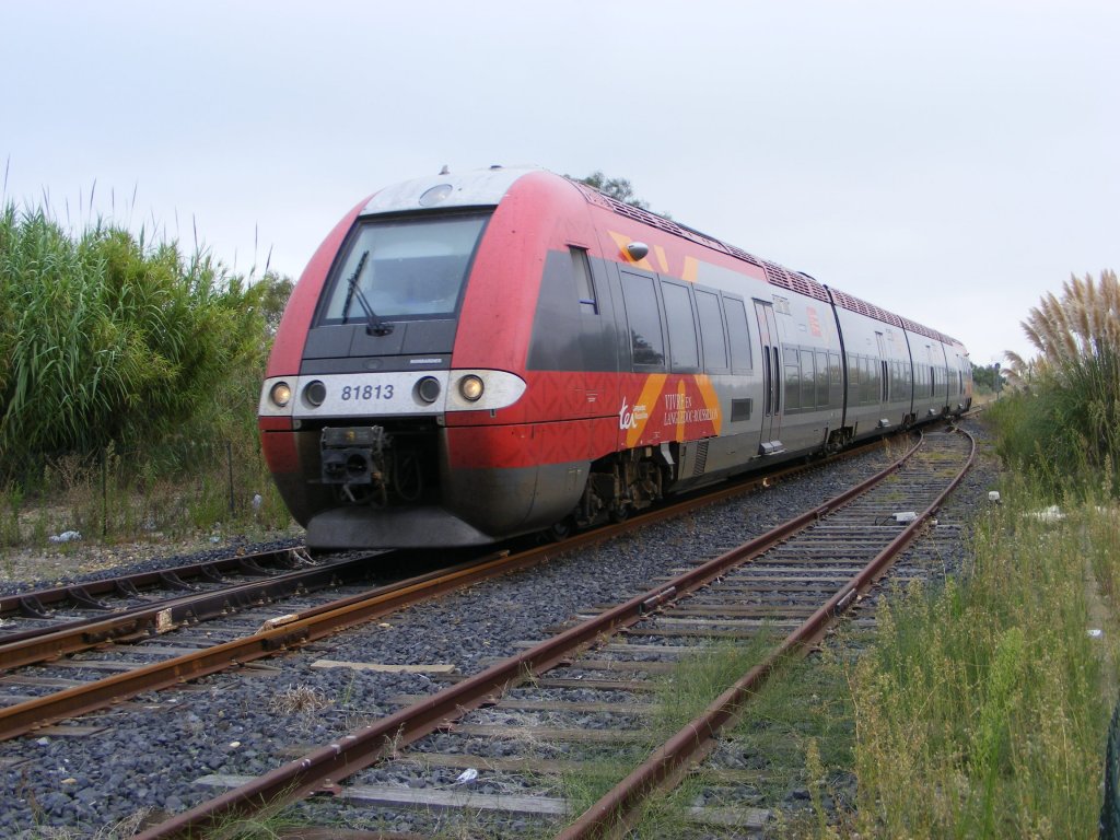 Frankreich 2010: Am 6.9.2010 erreicht der 81813 aus Nimes um 11:19Uhr die Bahnhofseinfahrt von Grau-de-Roi/Sdfrankreich (Der Himmel war an diesem Tag auch grau). Der franzsische Triebwagen verfgt sowohl ber ein Stromabnehmer als auch ber ein Dieselaggregat und wird von TER-SNCF betrieben. Eine Station vorher in Aigues Mortes musste der Zug ber eine Drehbrcke fahren. Die Region ist fr seine Salzgewinnung aus Meerwasser sehr bekannt.