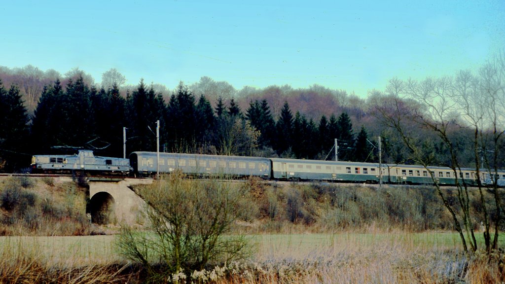 Frankreich, Lothringen, Meurthe-et-Moselle, zwischen Longuyon und Longwy. Eine BB 13000 fhrt mit dem Schnellzug Paris-Reims-Charleville-Luxemburg in Richtung Longwy. Die ersten Wagen sind ein DEV AO , 2 UIC-Y, ein DEV INOX. Scan eines Dias von Anfang 1976