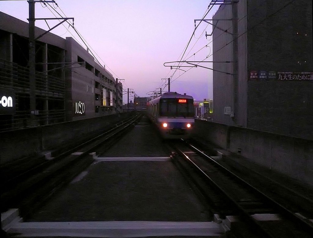 Fukuoka U-Bahn: Serie 2000 (6-Wagenzüge der zweiten Generation, Nr. 19-24, 1992-1998 gebaut). Im letzten Tageslicht fährt Zug Nr.22 (Frontwagen 2508) in der Station Kyûshû-Universität ein, leider umgeben von furchtbar viel Beton. 27.November 2010. 