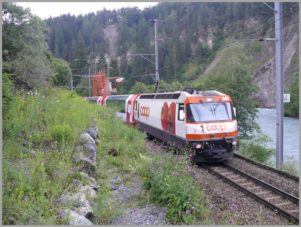 Ge 4/4 III 641  Maienfeld  zieht den GlacierExpress 909/911 aus der Station Trin. Hinter dem zweiten Wagen ist das Betonfundament fr die neue Hngebrcke ber den Rhein sichtbar, die fr Fussgnger gebaut wird. (20.06.2010)