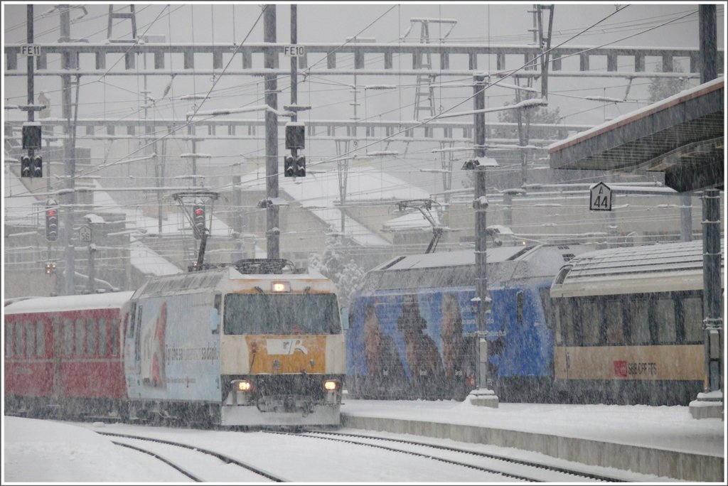 Ge 4/4 III 644  Savognin  und eine Werbe Re 460 begegnen sich am gemeinsamen Bahnsteig in Chur. (28.01.2010)
