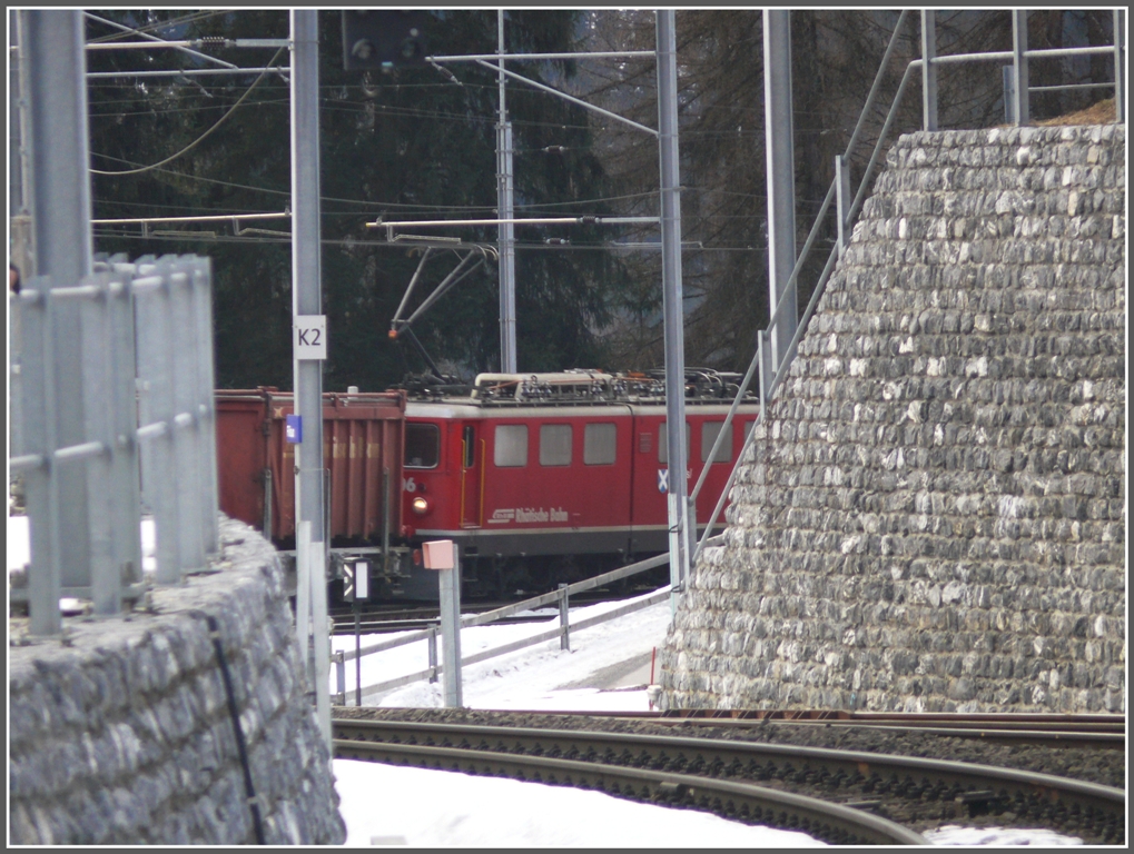 Ge 6/6 II 706  Disentis/Mustr  ist soeben an mir vorbei gefahren und windet sich aus dem Bahnhof Filisur Richtung Landwasserviadukt. Trotz abgeschnittener Lok und vieler Masten, gefllt mir das etwas andere Bahnbild, nur schon wegen der schnen Mauern links und rechts der neuen Doppelspur. (24.01.2011)