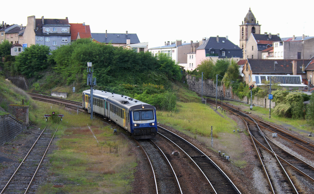 Gegen 18.00 Uhr wird es im Bahnhof von Saargemnd lebendig. Aus allen Richtung laufen Zge in Sarreguemines ein.

SNCF TER 4769 kommt aus Bning-les-Saint Avold den Berg hinunter gerollt.
Rechts ist die Bahnstrecke nach Saarbrcken zu sehen, das deutsche Vorsignal zeigt dass die Landesgrenze zu Deutschland nicht mehr weit ist.
Der Fahrdraht mit deutscher Spannung dient der Saarbahn die auf Gleis 1 bis in den Bahnhof von Saargemnd fhrt.
15.09.2011