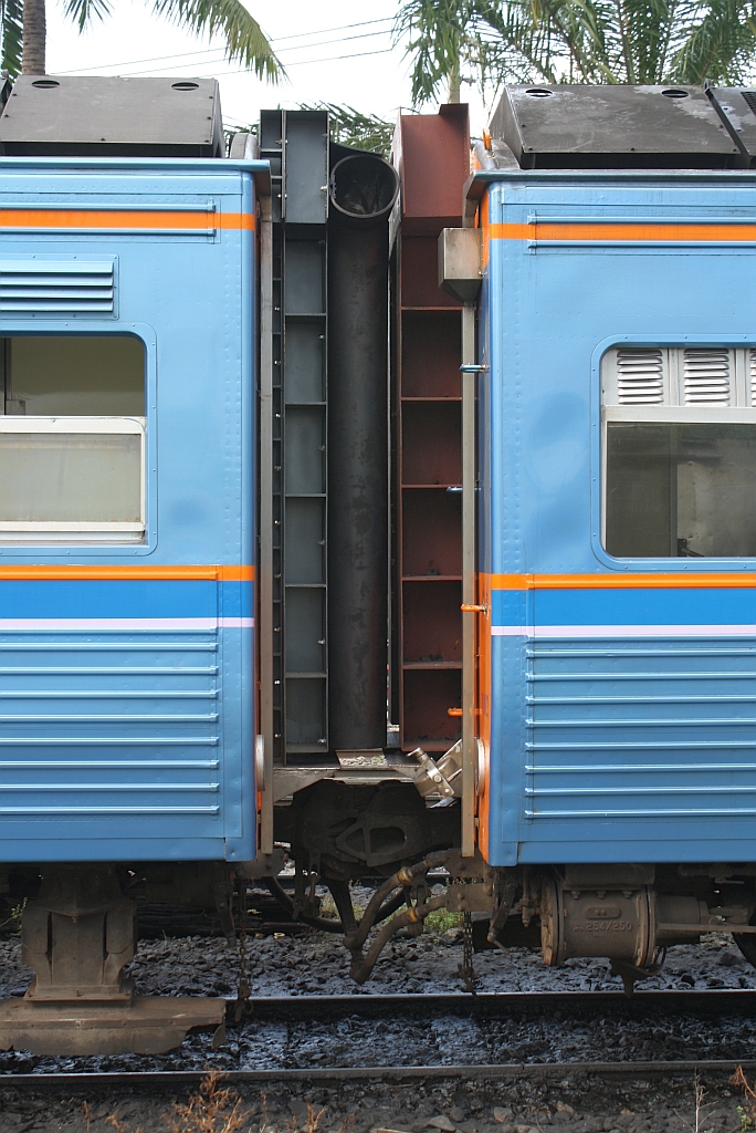 Gemeinsam mit einem neuen Outfit erhalten die Triebwagen der Type THN nun auch geschlossene Übergänge mit Gummiwulst. Diese einfache Ausführung der Übergänge stellt allerdings ein betriebliches Problem dar, da ein bisher übliches x-beliebiges kuppeln der Triebwagen nun wegen der möglichen Konfiguration geschlossener Übergang/offener Übergang mit Handgriffe nun nicht mehr möglich ist. Deshalb kann auch im Schadensfall von nur einem Triebwagen der Zweite nicht uneingeschränkt weiter verwendet werden. Übergang von THN 1102 auf THN 1105 am 15.November 2012 im Depot Thon Buri.

