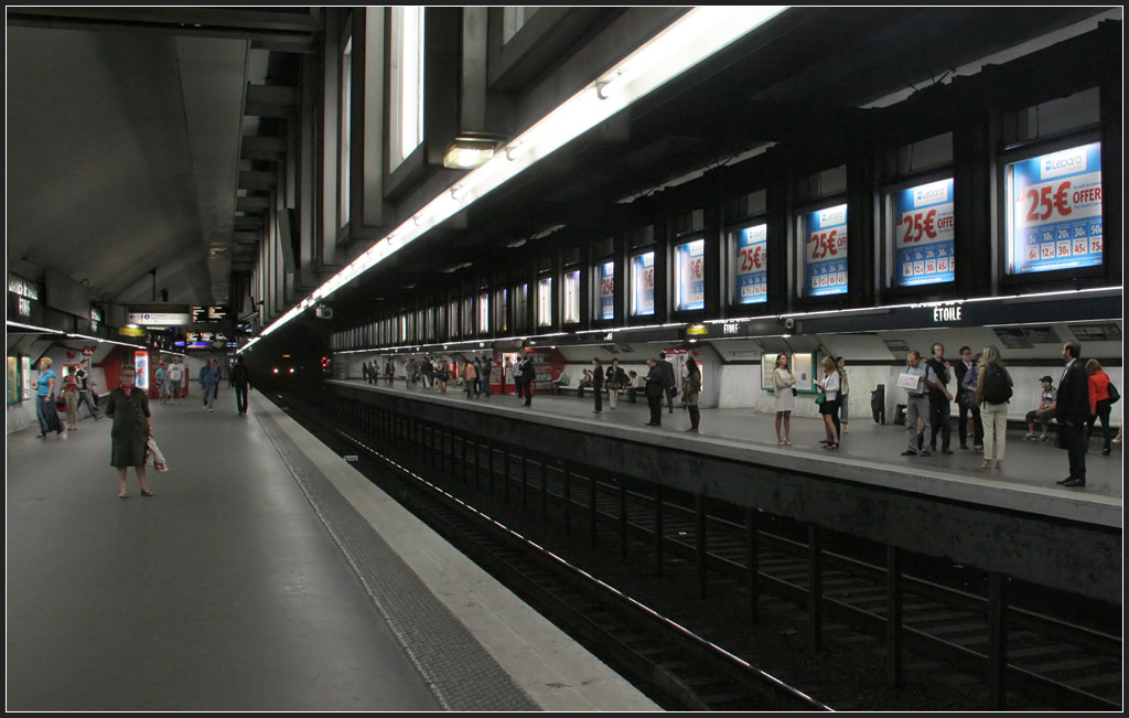 Geprägt durch die Reklame - 

In der RER-Station  Charles-de-Gaulle-Étoile  hängen über den Bahnsteigkanten beleuchtete Werbevitrinen, die den Charakter der Station hier ausmachen. Die tiefliegende Haltestelle wurde bergmännisch gebaut, erkennbar an der Gewölbeform. Darüber liegen die Station dreier Metrolinien. 

18.02.2012 (M)