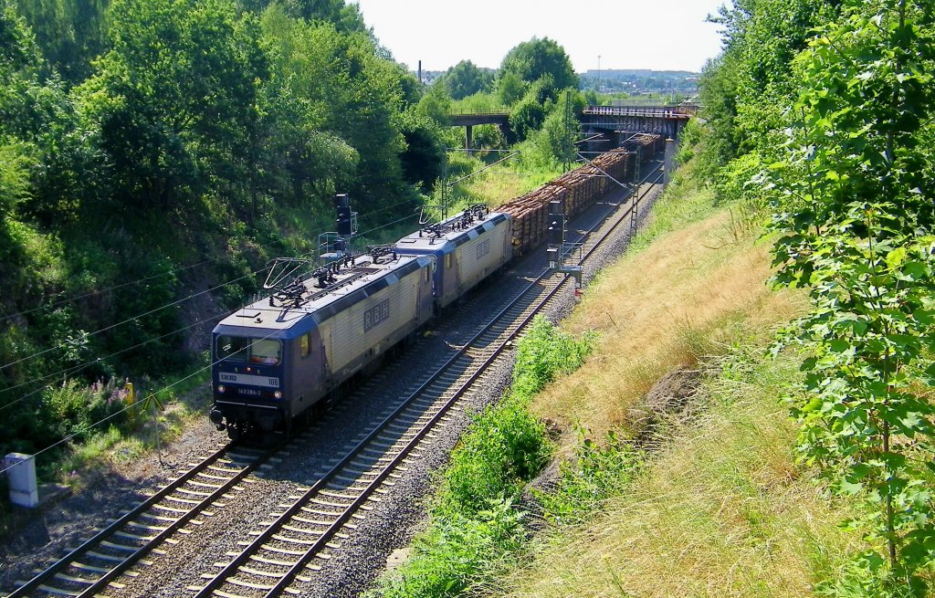 Gerade hat das RBH-Doppel mit der 143 286-3 voran (RBH 106) mit ihrem langen Holzzug die Gterbahngleise des Bahnhof Freiberg verlassen und fhrt nun hier am Stadtrand von Freiberg Richtung Dresden (02.08.2013) 