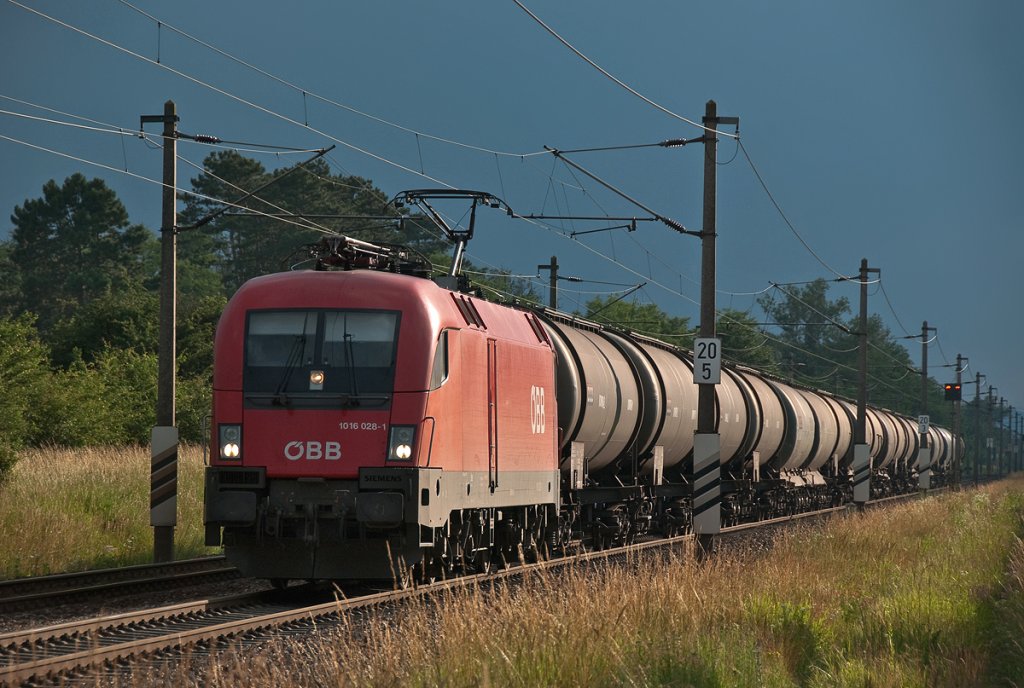 Gewitterstimmung an der Nordbahn. 1016 028 befrdert einen Kesselwagenzug Richtung Gnserndorf. Helmahof, am 19.06.2010.