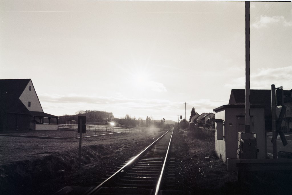 Glnzende Gleise in der Abendsonne am Bahnbergang. Aufgenommen am 14. Januar 2013 und gescannt vom S/W-Film.