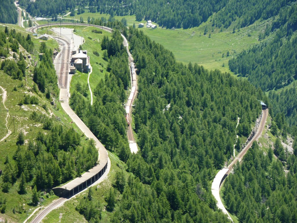 Gleich auf 4 verschiedenen Ebenen sieht man die Bernina-Bahn bei der Station Alp Grm. Rechts vom Bahnhof fhrt am 7.7.2010 ein R nach St. Moritz in Richtung Bernina Pass.