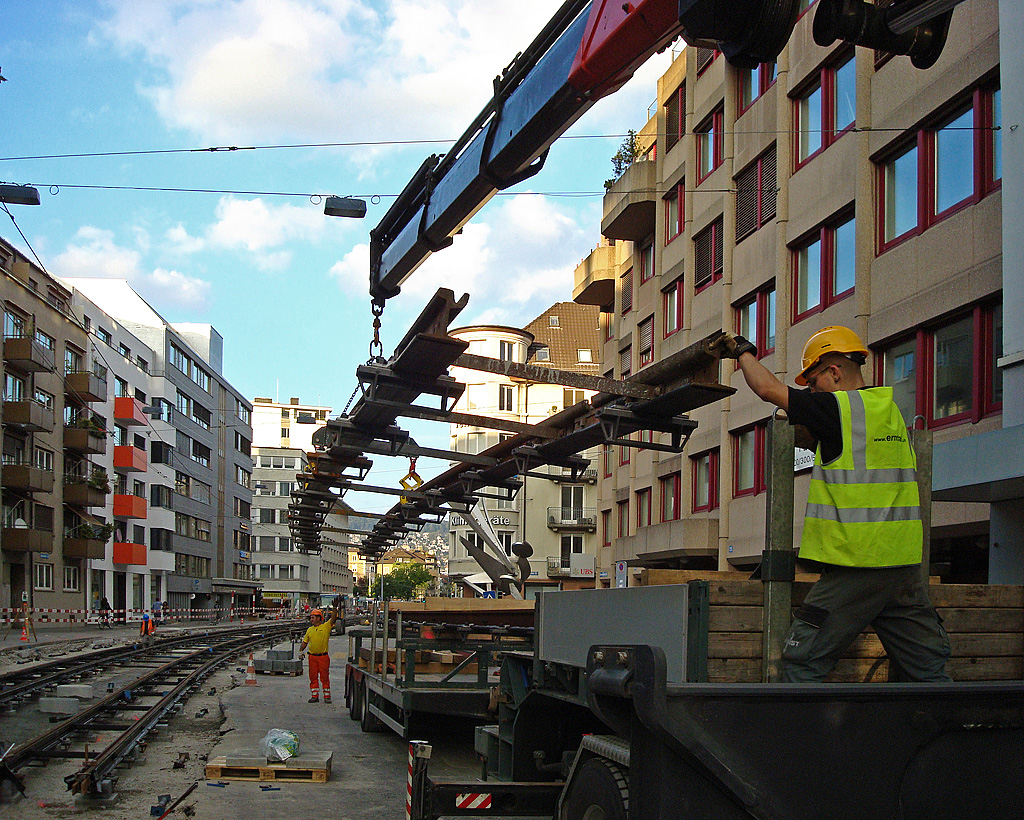Gleiserneuerung an der Birmensdorferstrasse. In ein paar Sekunden wird das am Kran hngende Gleis an der gewnschten Stelle sein. Kaum zu glauben, dass am bernchsten Tag (06. Sept.) wieder Trams fahren. Schmiede Wiedikon, 04. Sept. 2010, 19:08